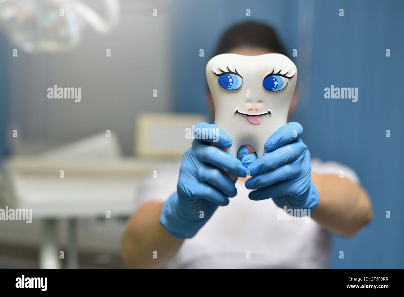 Donna bambini dentista che mostra un grande dente giocattolo Foto Stock