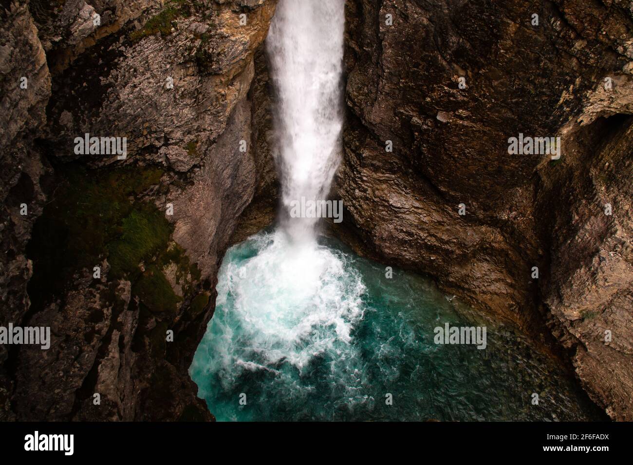 Moody immagine scattata durante un'escursione estiva alle Upper Falls del Johnston Canyon vicino a Banff, Alberta, Canada. L'acqua turchese alla base della cascata lo rende Foto Stock
