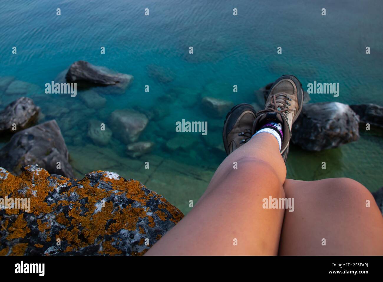 Scarponi da escursionista e affioramento roccioso con eleganti licheni al sole vicino alla Grotta, al Bruce Peninsula National Park, Ontario, Canada (Georgian Bay). Foto Stock