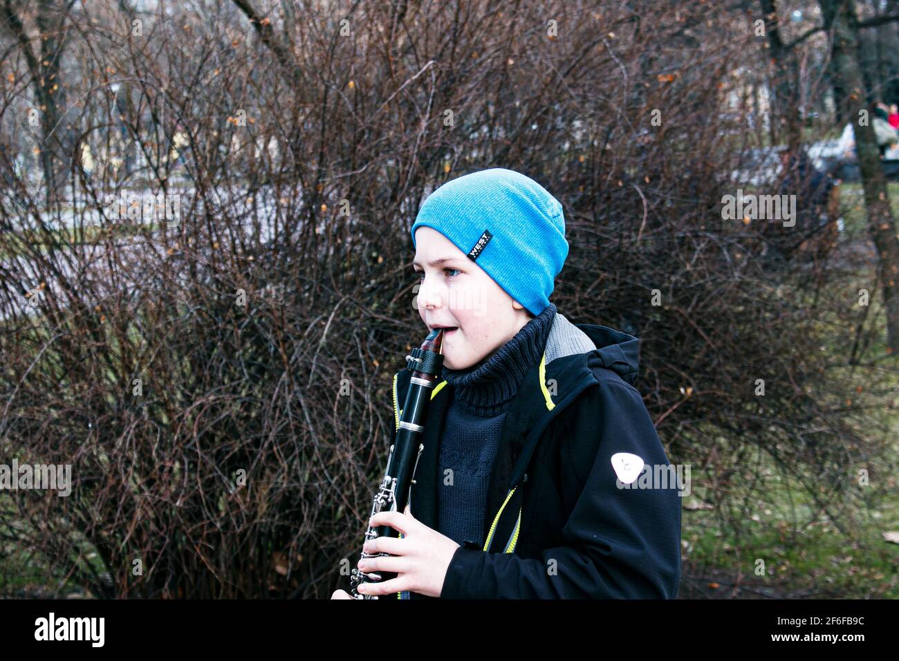 Dnepropetrovsk, Ucraina - 03.29.2021: Un ragazzo nel parco suona il clarinetto. Il bambino è di buon umore. Foto Stock