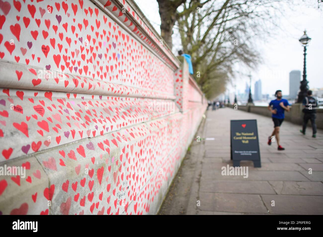 Londra, Regno Unito. 31 marzo 2021. La gente passa accanto al Muro commemorativo COVID-19 sull'argine, nel centro di Londra, che è stato dipinto con cuori in memoria delle oltre 145,000 persone che sono morte nel Regno Unito a causa del coronavirus. Data immagine: Mercoledì 31 marzo 2021. Il credito fotografico dovrebbe essere: Matt Crossick/Empics/Alamy Live News Foto Stock