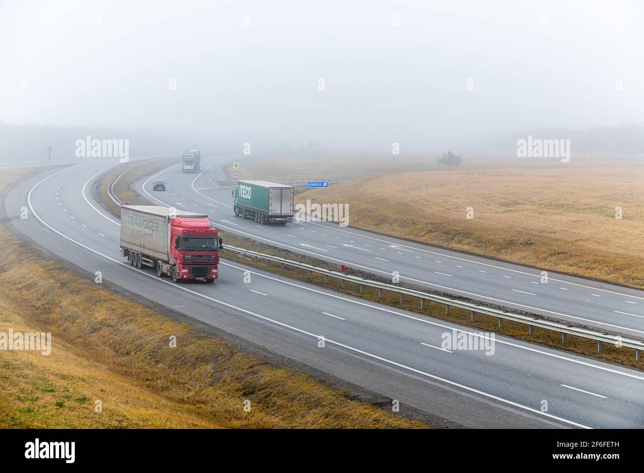 Tatarstan, Russia, autostrada interstatale M7 - 04 novembre 2020. I camion si spostano lungo l'autostrada federale verso la loro destinazione. Indicatore di direzione verso la città Foto Stock