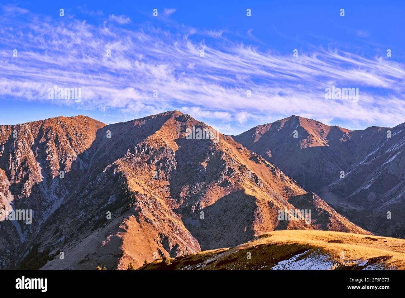 Maestose montagne autunnali con spettacolari nuvole contro il cielo blu all'alba Foto Stock