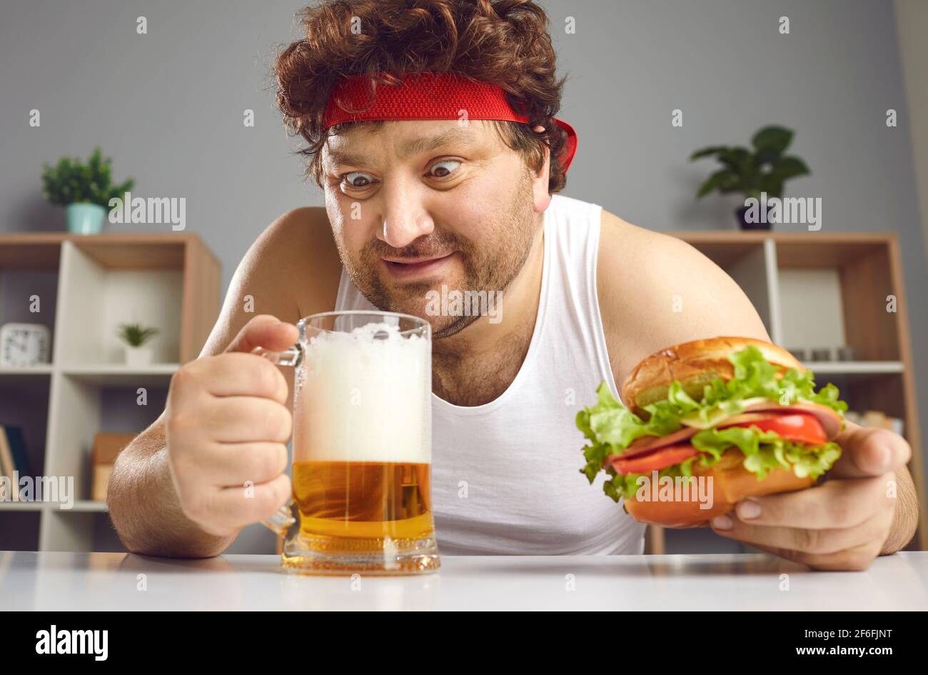 Eccitato pazzo uomo grasso bere birra e mangiare hamburger headshot verticale Foto Stock