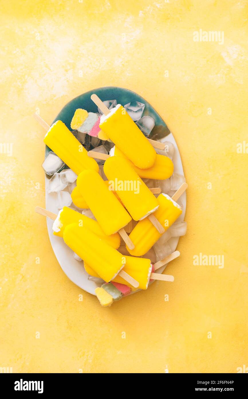 Papsicli fruttati. Vegan varie coloratissime lecci di ghiaccio su un piatto. Vista dall'alto, spazio vuoto Foto Stock