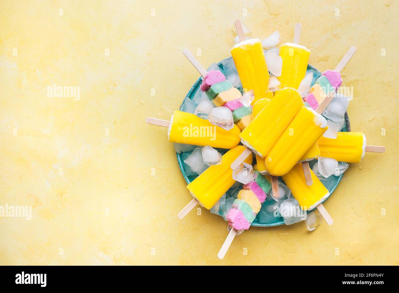 Papsicli fruttati. Vegan varie coloratissime lecci di ghiaccio su un piatto. Vista dall'alto, spazio vuoto Foto Stock