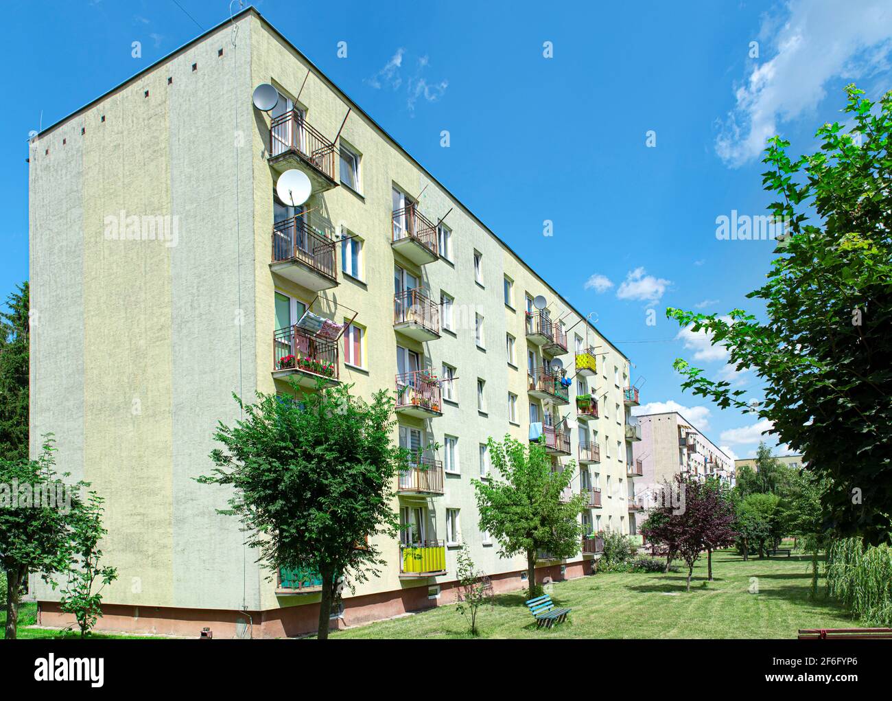 Elevazione verde e facciata colorata di blocco di appartamenti in proprietà. Paesaggio urbano del blocco di alloggiamento con lavanderia sui balconi, Polonia Foto Stock