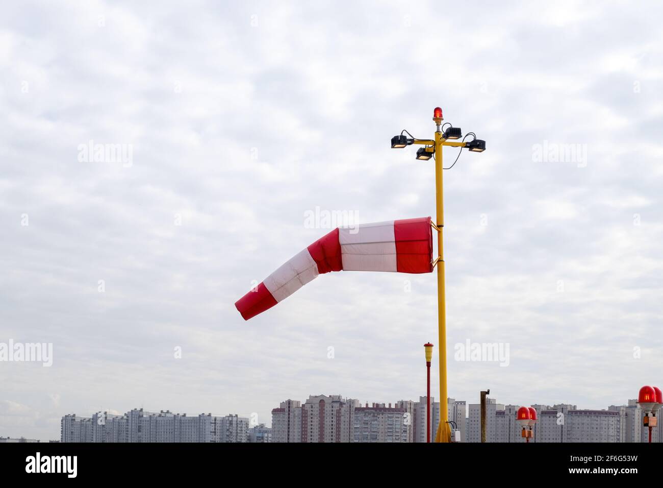 Indice del vento contro il cielo nuvoloso e lo skyline della città. Foto Stock