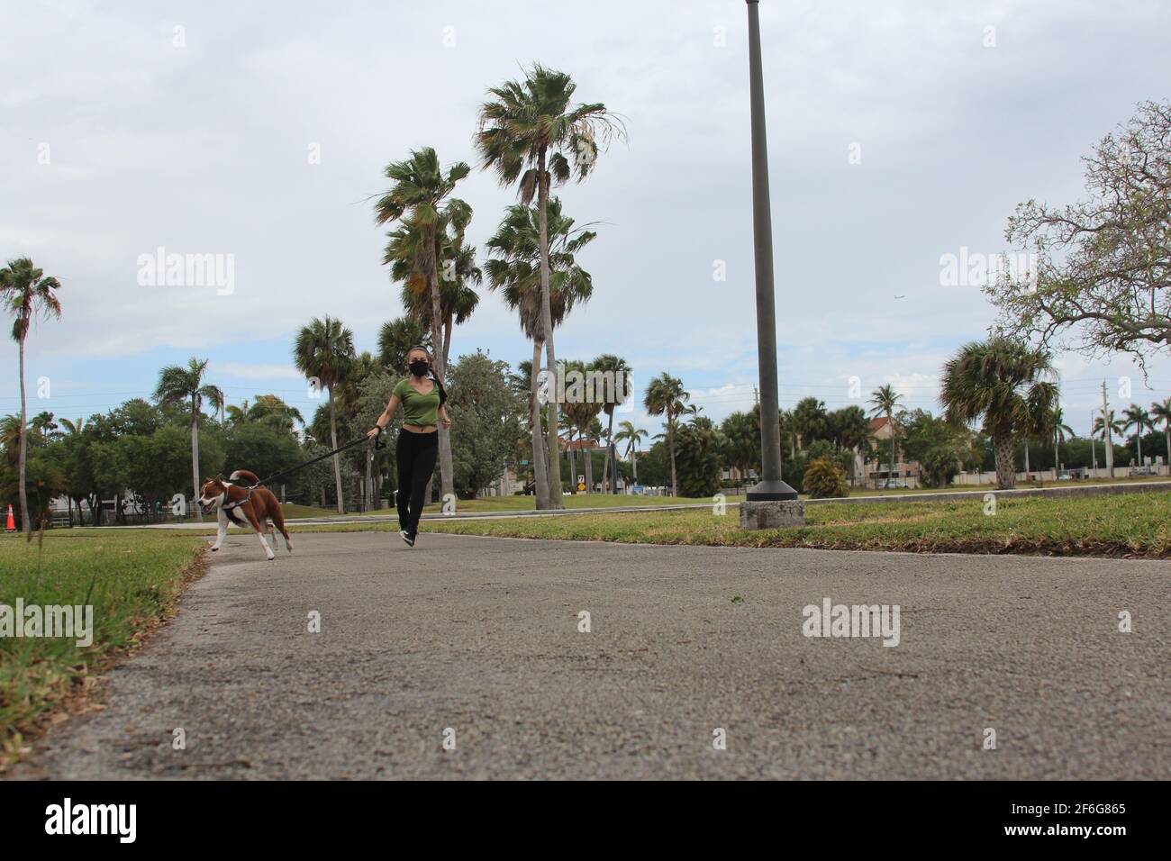 Donna che corre con il suo cane nella nuova normalità Foto Stock