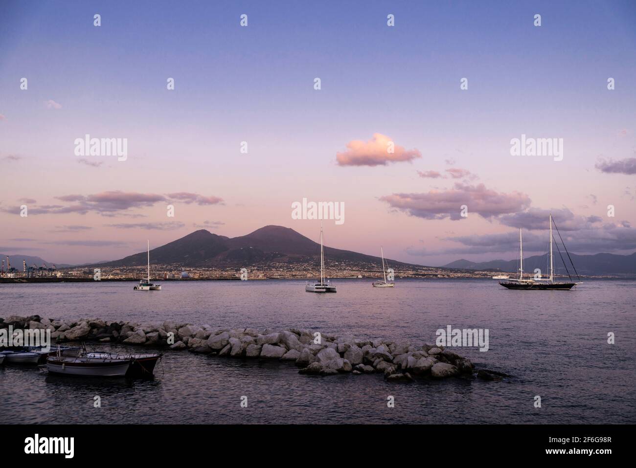 Barche a vela, barche e catamarani ormeggiati o in barca a vela al tramonto  sul golfo di Napoli di fronte al Vesuvio, Italia Foto stock - Alamy