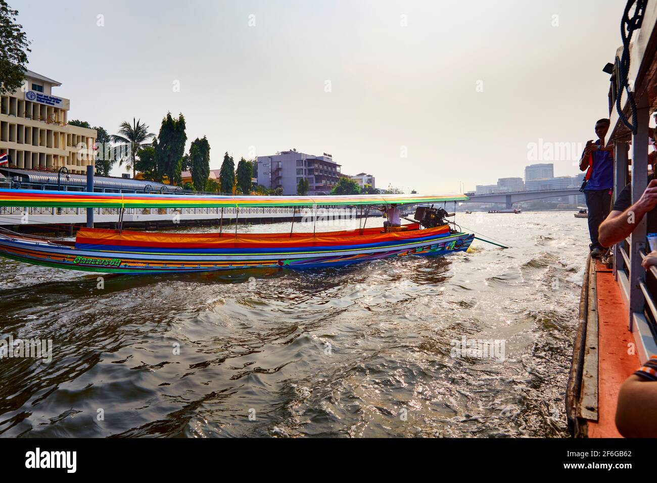 Tradizionale barca Thailandia a coda lunga con turisti che passano lungo il fiume Chao Phraya nel pomeriggio, circondato dallo sfondo di Bangkok, Tha Foto Stock