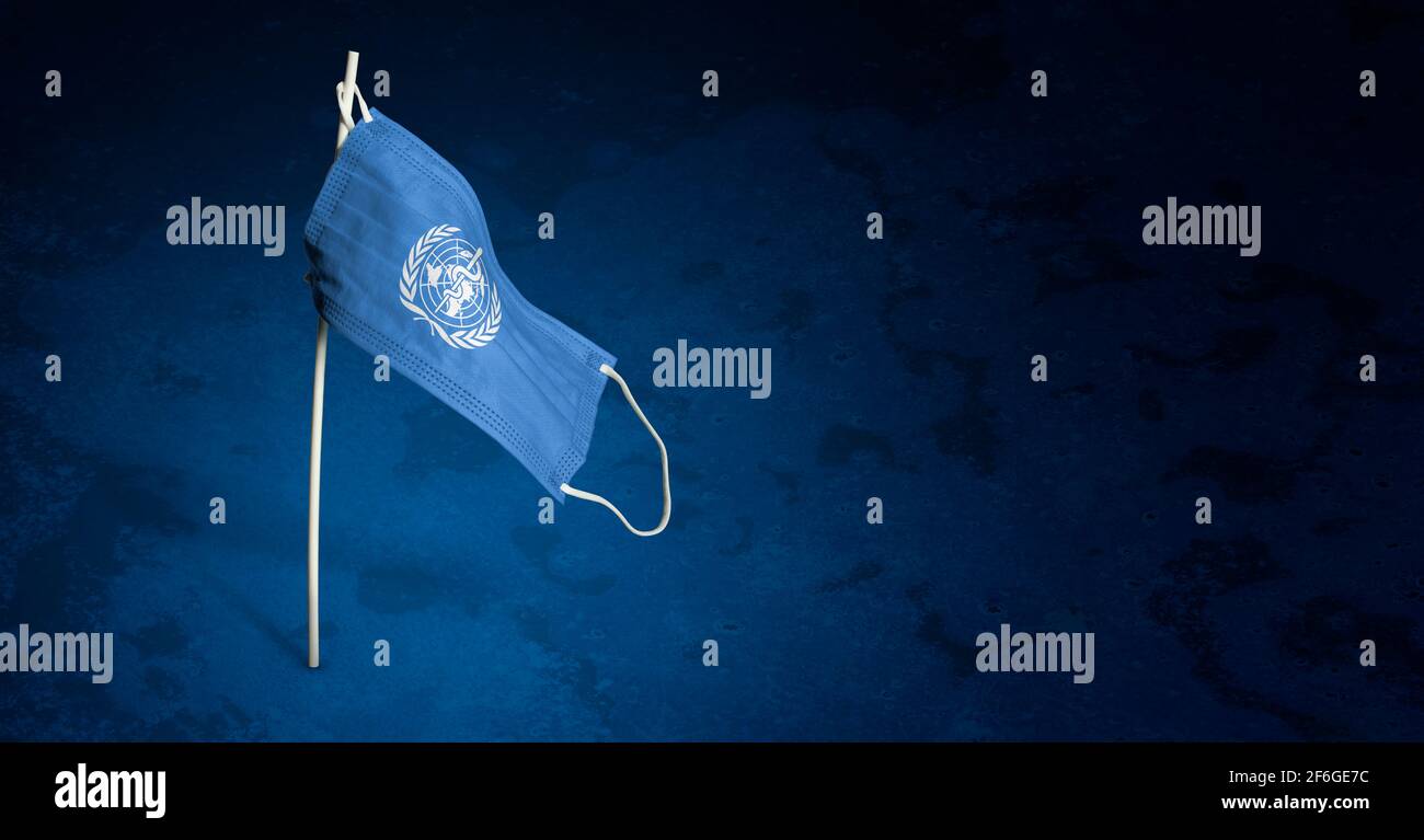 Maschera dell'Organizzazione Mondiale della Sanità su sfondo blu scuro. Bandiera sventolante di CHI dipinse su maschera medica sul palo. Flag di attacco del virus. Concetto del banner o Foto Stock