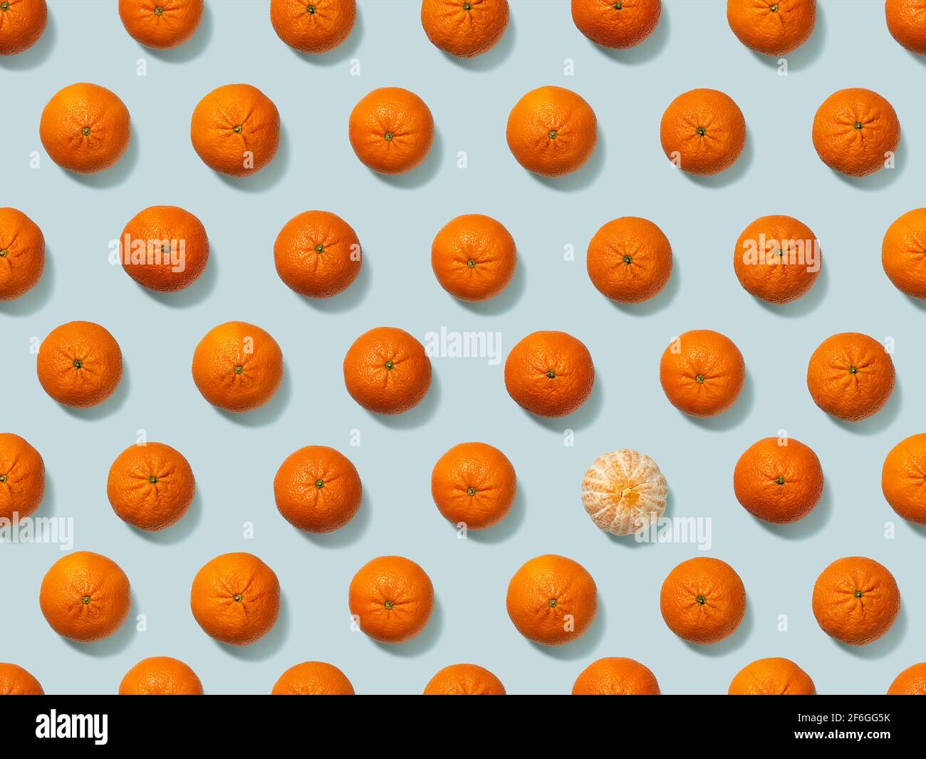 Tangerini su sfondo azzurro. Modello senza cuciture, per carta da imballaggio. Individuare le differenze. Foto Stock