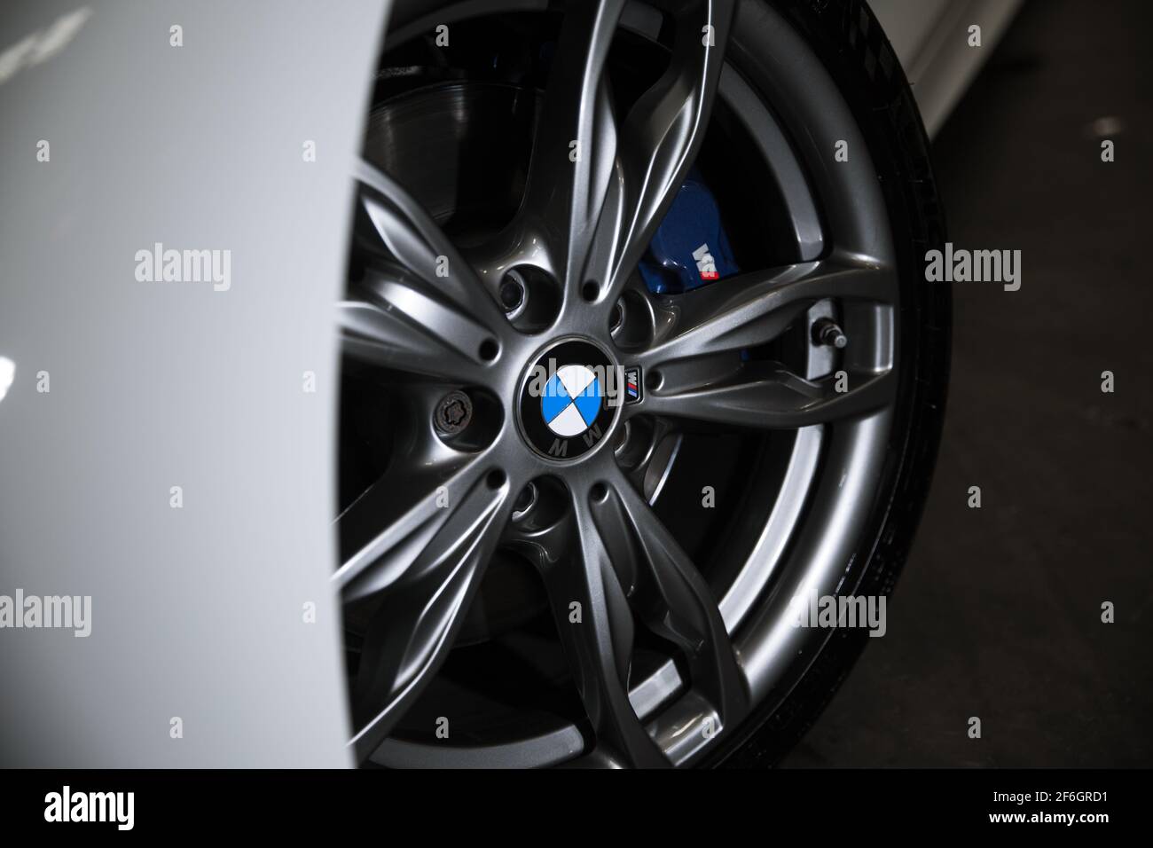 Il logo BMW sulla ruota della vettura su Una BMW M140i 2016 con finitura Diamond Cut e blu Pinze freni M Performance Foto Stock