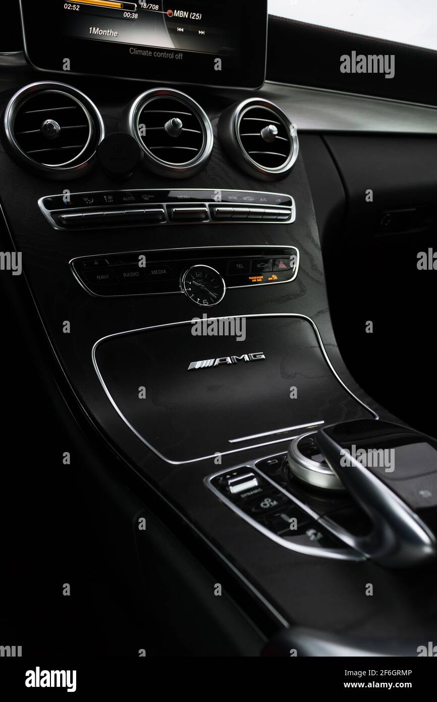 Una leva del cambio automatica all'interno della Mercedes Benz C63 2016 AMG Cabriolet con console centrale effetto legno scuro Foto Stock