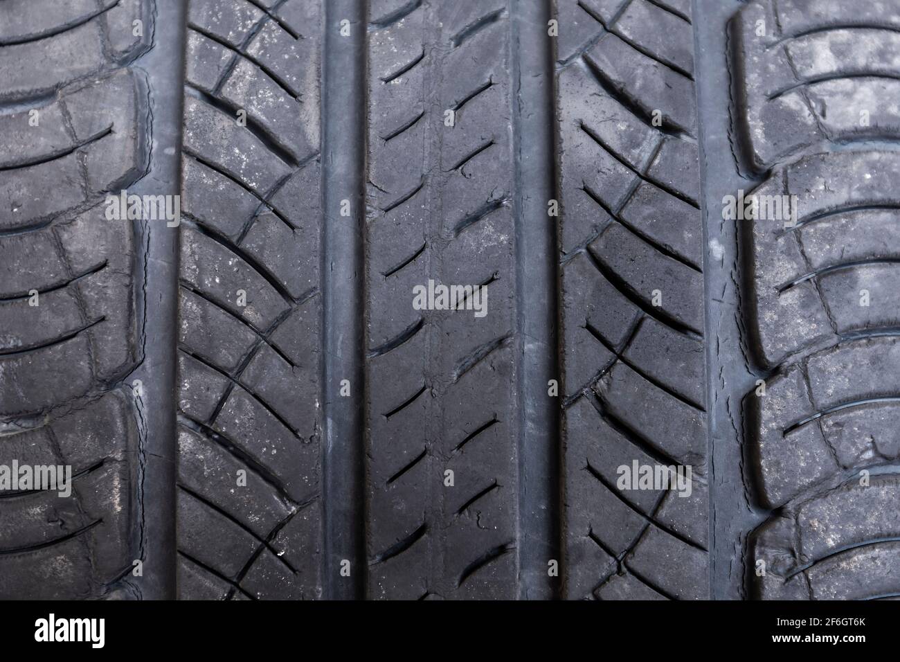 Primo piano sfondo del vecchio pneumatico macro , tampone in gomma antiscivolo realizzato con il vecchio pneumatico. Pneumatico vecchio danneggiato. Copertura pneumatico per auto. Consistenza della gomma sulle ruote Foto Stock
