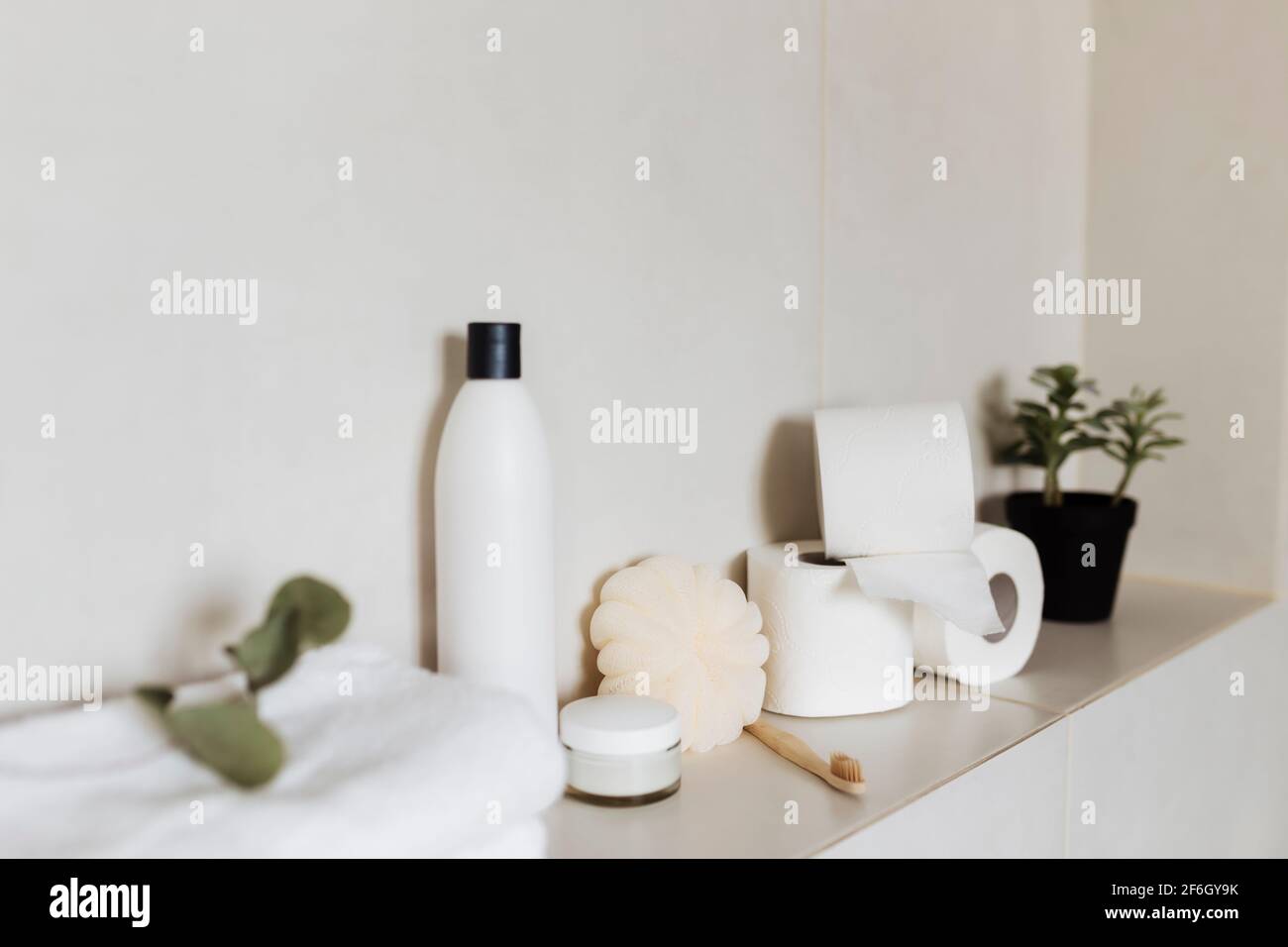 Bagno bianco con accessori da bagno. Concetto di pulizia dell'hotel. Concetto domestico. Lavabo, shampoo, crema, carta igienica, pianta, spazzolino da denti. Qual alta Foto Stock