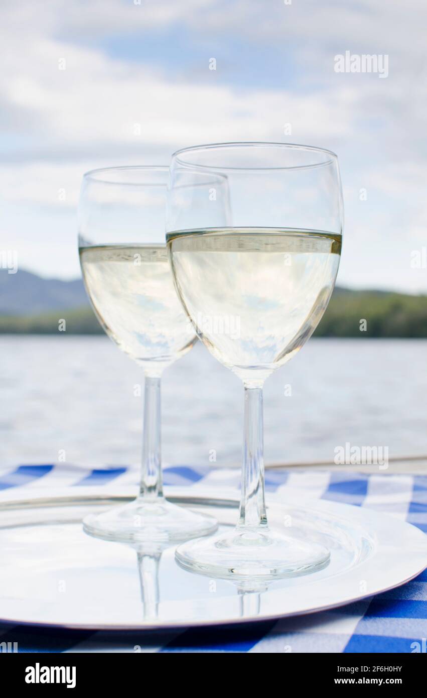 Stati Uniti, New York, Lake Placid, due bicchieri di vino bianco su vassoio di Lake Placid Foto Stock