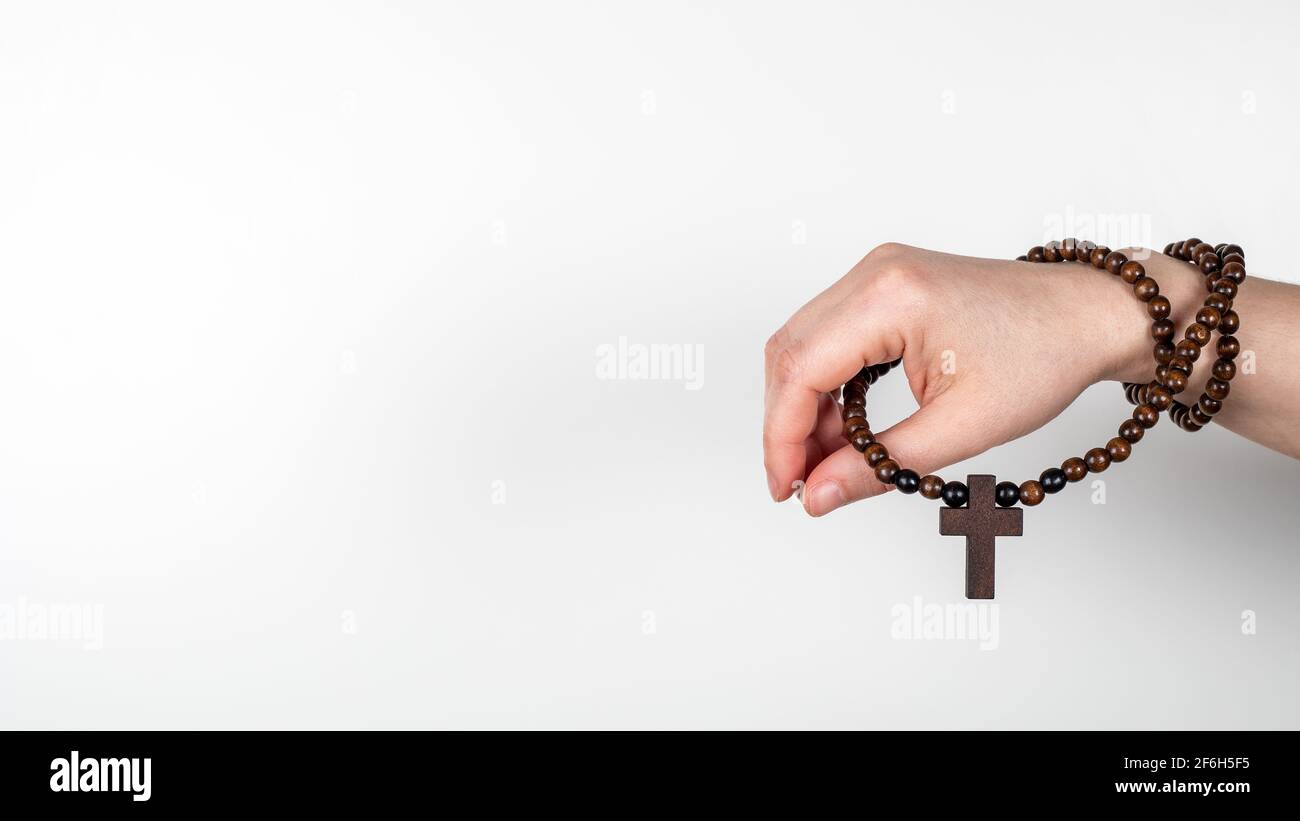 Croce di legno sulla mano della donna. Banner orizzontale con spazio per il testo, mock-up. Foto Stock