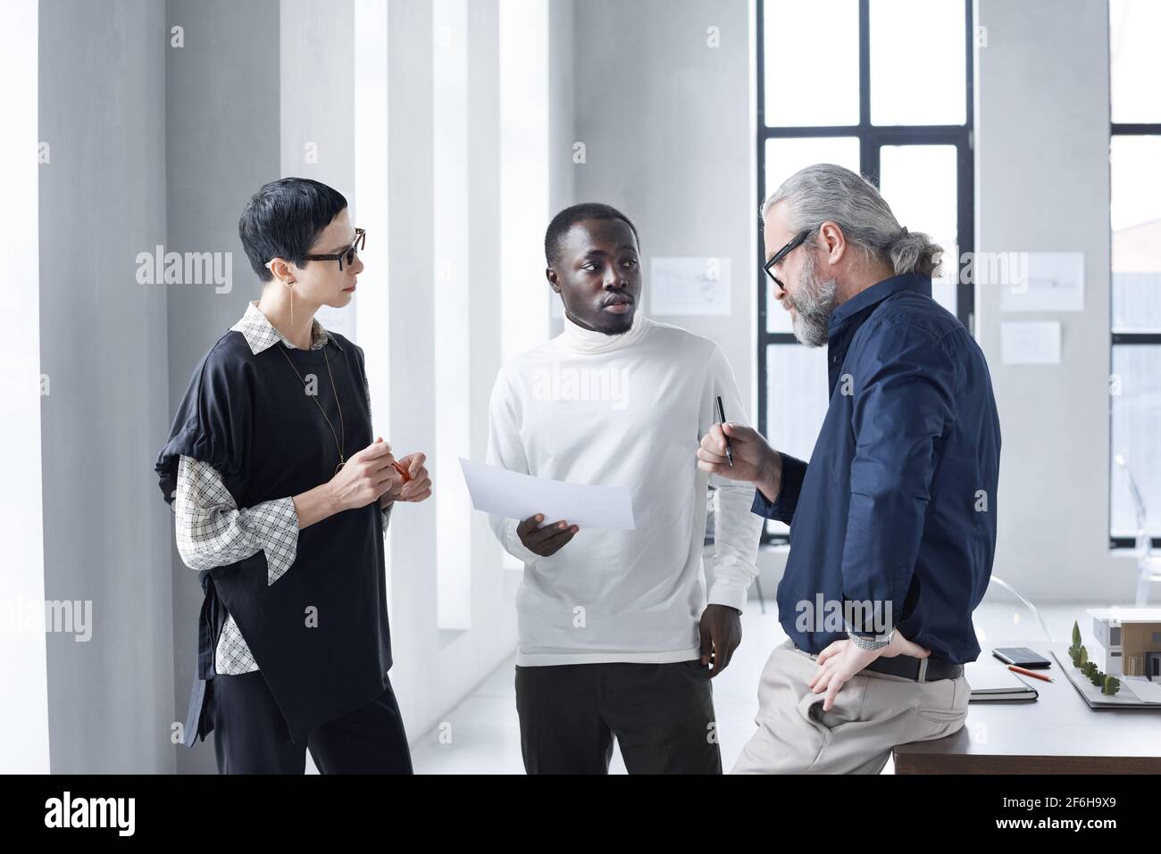 Gli uomini d'affari discutono dei momenti di lavoro mentre lavorano in squadra a. ufficio Foto Stock