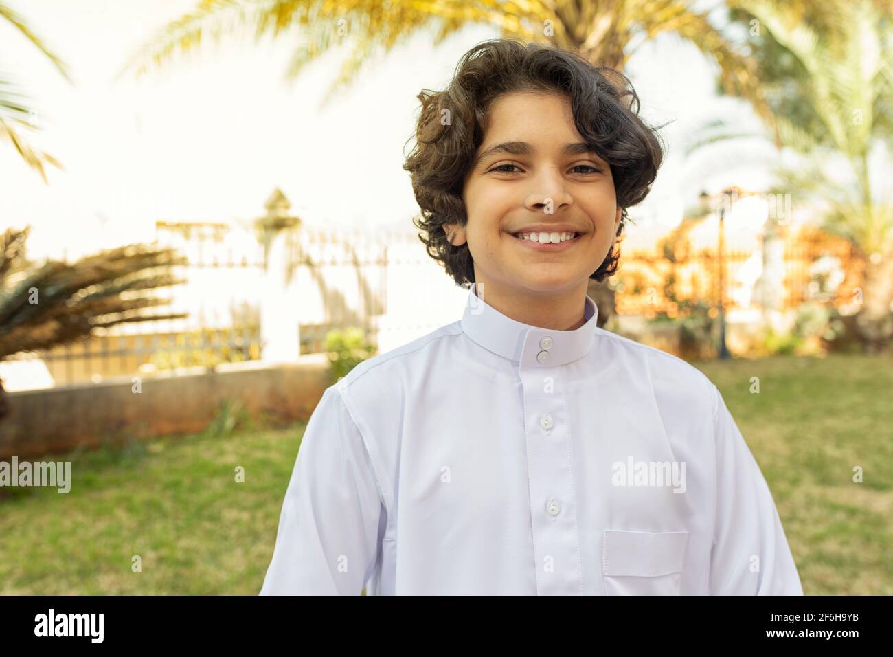 Ragazzo arabo che indossa abiti tradizionali sorridendo all'aperto Foto Stock