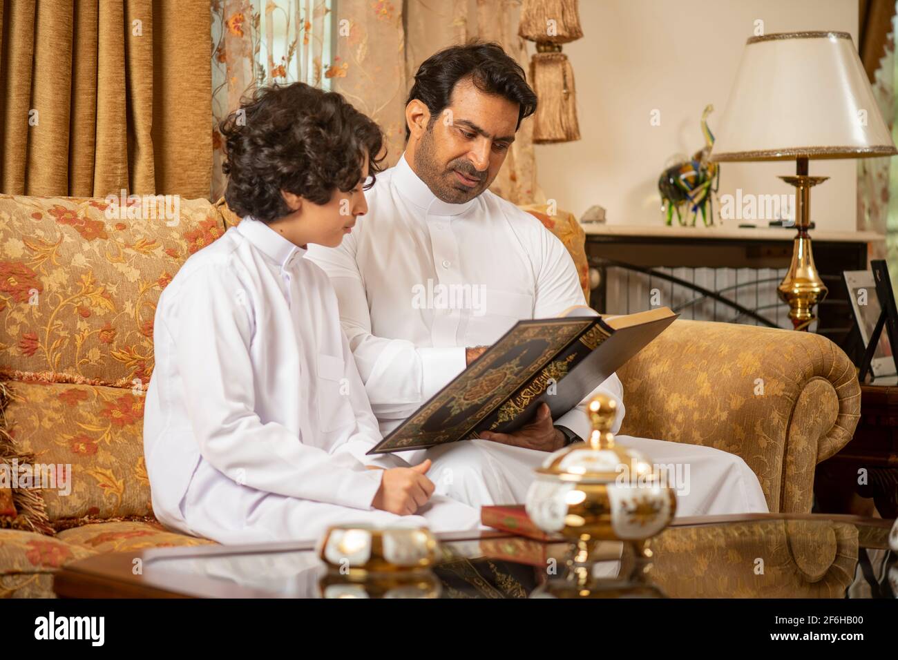Padre arabo e Figlio che legge il Libro Sacro di Corano Foto Stock