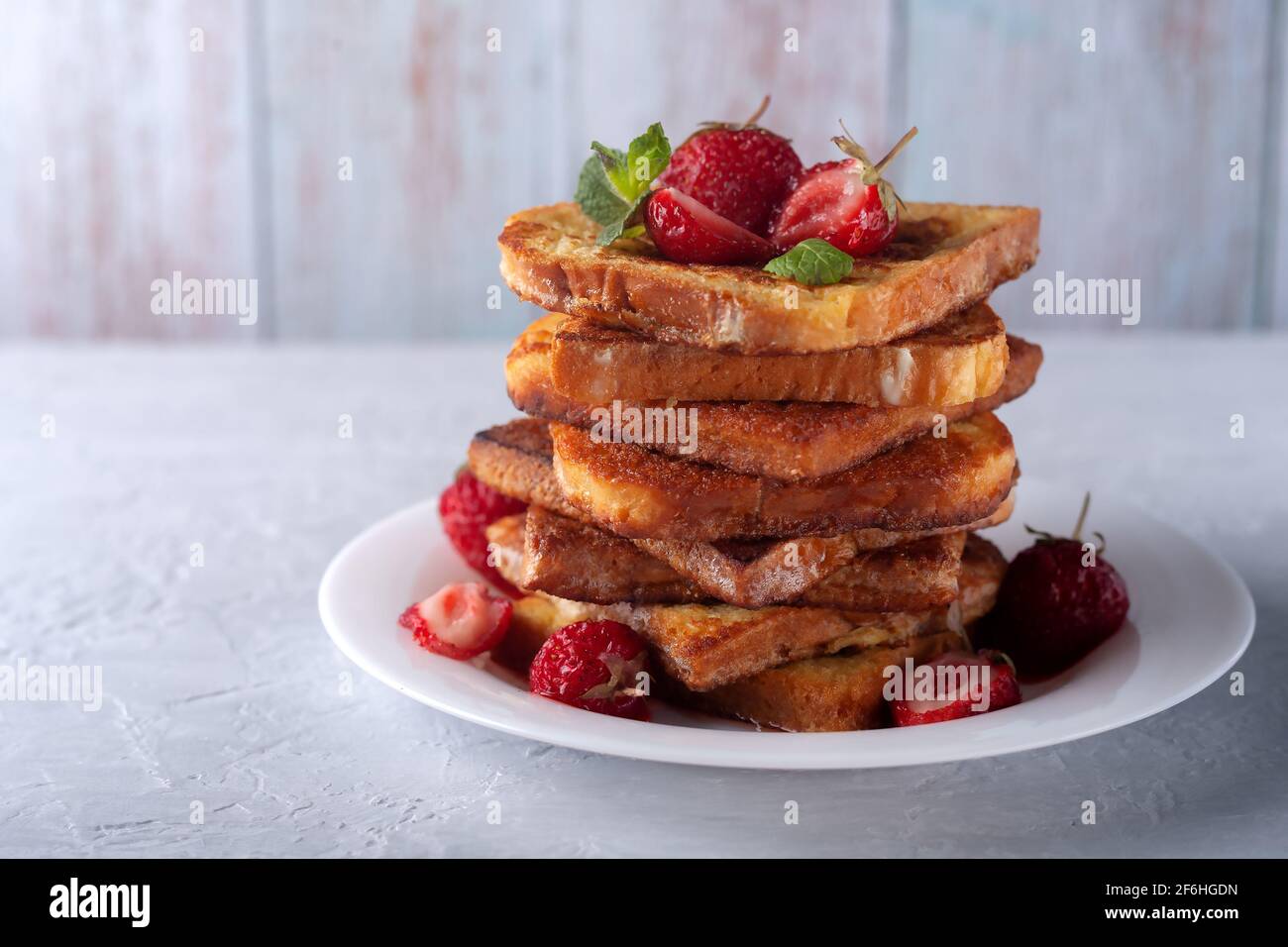 Toast alla francese con cannella, fragole e menta per caffè o tè. Colazione del mattino Foto Stock