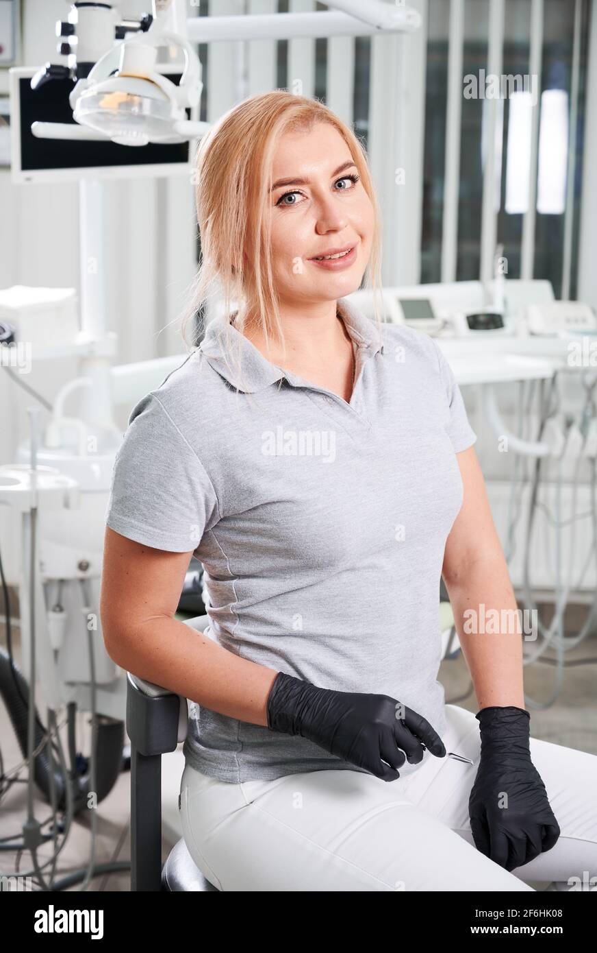 Ritratto di dentista femminile seduto nel suo ufficio dentista. Foto Stock
