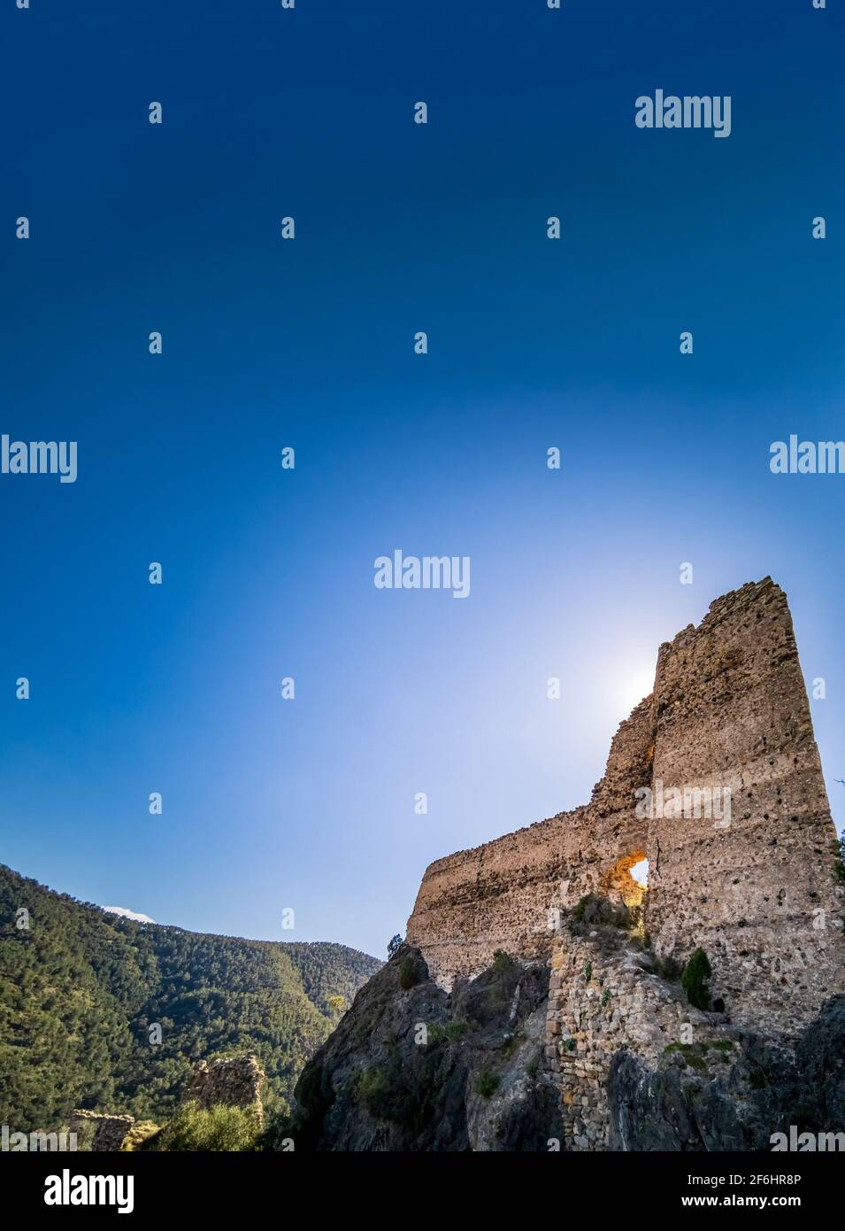 Retroilluminata di vecchio castello in rovina sulla cima delle rocce Foto Stock