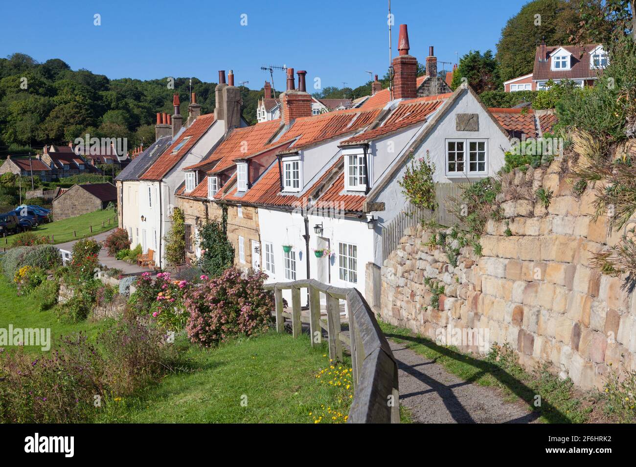 Attraente vista estiva di una fila di tradizionali cottage di pescatori Nel villaggio di Sandsend sulla costa dello Yorkshire settentrionale Foto Stock