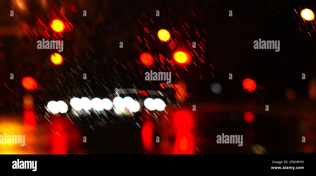 pioggia che si riversa sul vetro con riflessi dai fari e dai semafori sulla strada. Durante le inondazioni a Sydney nel marzo 2021. Foto Stock