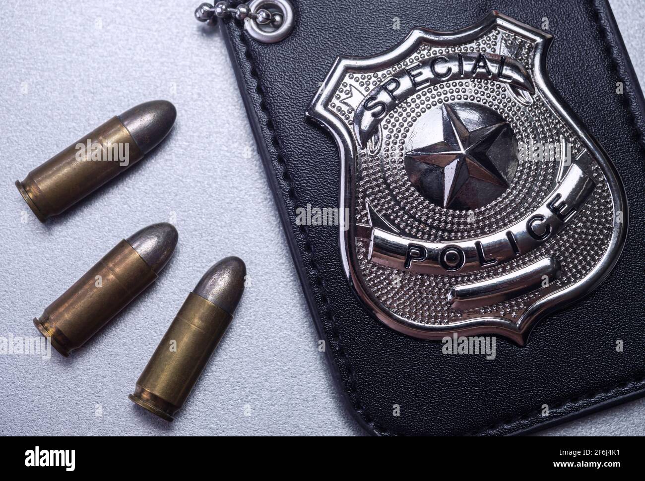 Badge della polizia accanto ai proiettili, immagine concettuale Foto Stock