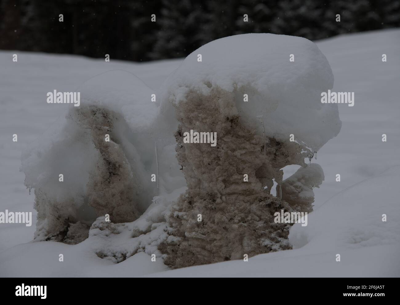 neve mound di sporco vecchia neve ghiacciata con una spolverata di neve fresca fresca bianca sulla parte superiore forme astratte formato orizzontale con spazio per il tipo Foto Stock