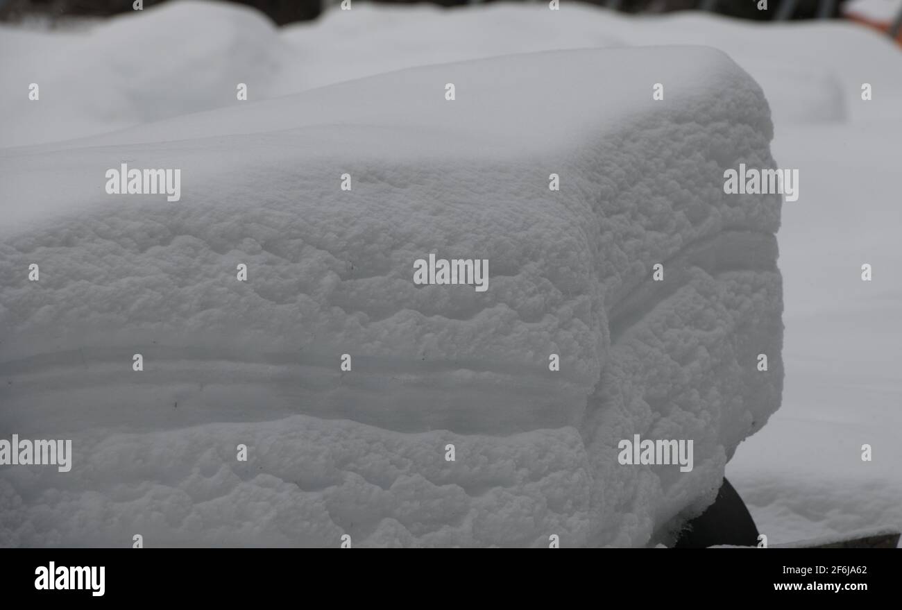 pezzo rettangolare di neve che rivela strati di diversi tipi e pesi di strati di neve a seconda della quantità climatica di nevicate nel carico invernale di neve Foto Stock