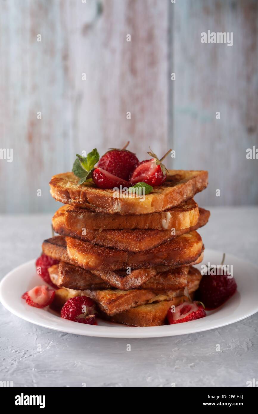 Toast alla francese con cannella, fragole e menta per caffè o tè. Colazione del mattino Foto Stock