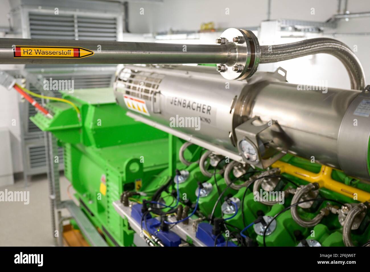 GERMANIA, Amburgo, un'unità di cogenerazione Megawatt per il riscaldamento e l'alimentazione con gas naturale o idrogeno verde, tubo H2 e generatore di motori a gas Jenbacher / DEUTSCHLAND, Amburgo, Hansewerk Natur, BHKW Blockheizkraftwerk 1 MW Klasse, das über Kraft-Wärme-Kopg suneine Siedlung mit Strom und Wärme versorgt, Energiequellen Erdgas oder Grüner Wasserstoff gewonnen aus erneuerbarer Energie, Wasserstoff Zuleitung fuer Jenbacher Gasmotor, der wahlweise grünen Wasserstoff oder Erdgas verbrennen kann Foto Stock