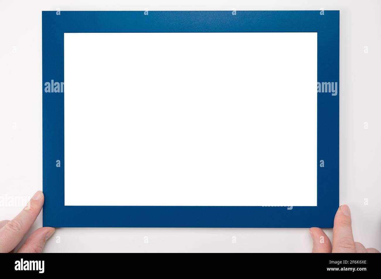 Mockup del telaio di supporto. Uomo mani tenere telaio. Appeso mockup cornice blu sulla parete bianca. Mockup diploma. Uomo appeso foto mockup sulla parete. Certificato, di Foto Stock