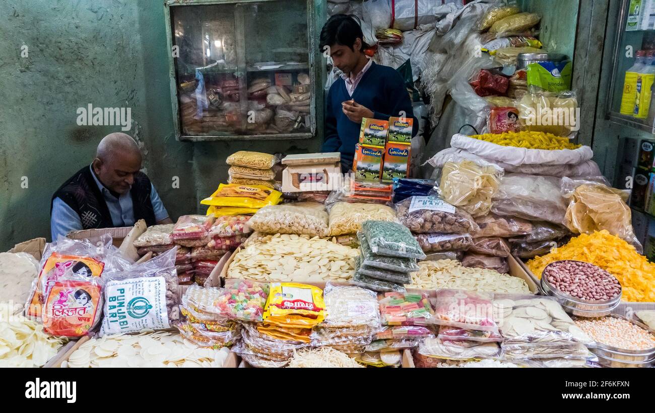 Kolkata, Bengala Occidentale, India - Gennaio 2018: Negozianti in un negozio che vende spuntini assortiti in una vecchia strada del mercato nella città di Kolkata. Foto Stock