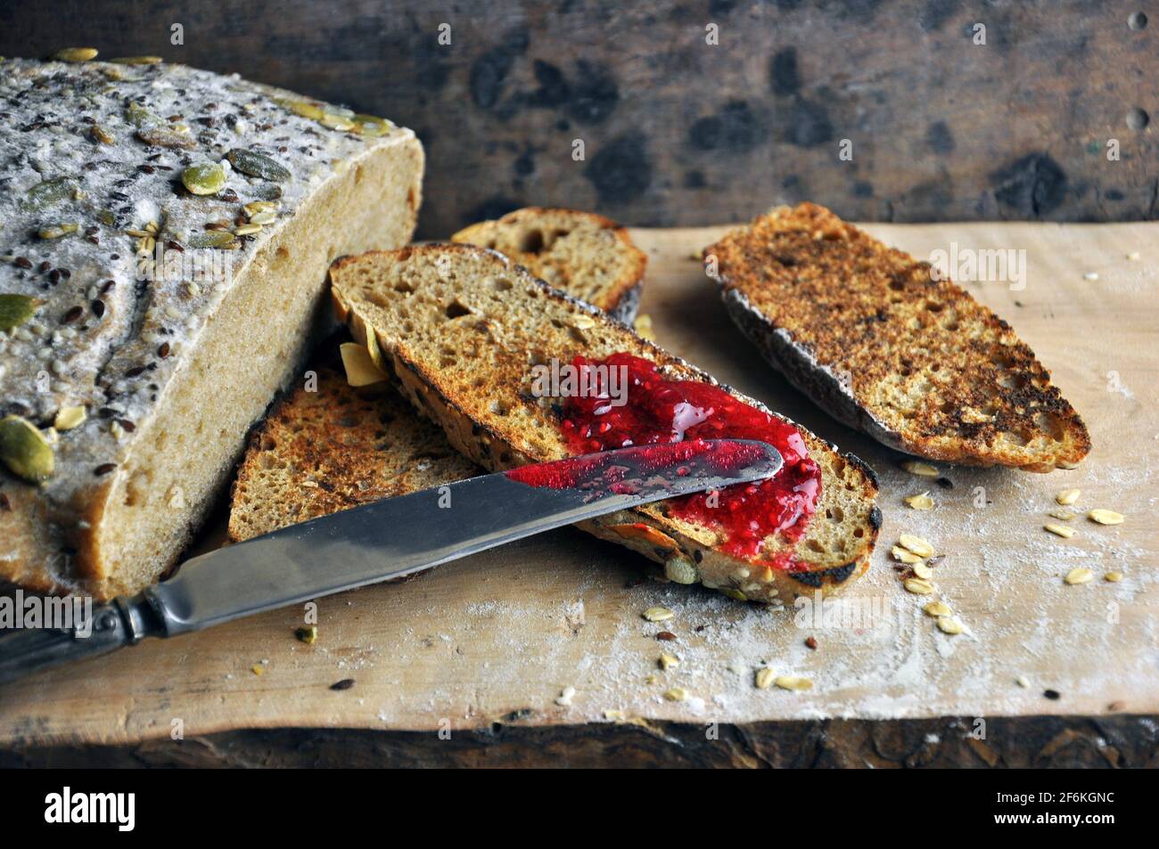Pane tostato fresco con marmellata di frutti di bosco fatta in casa su sfondo di legno. Foto Stock