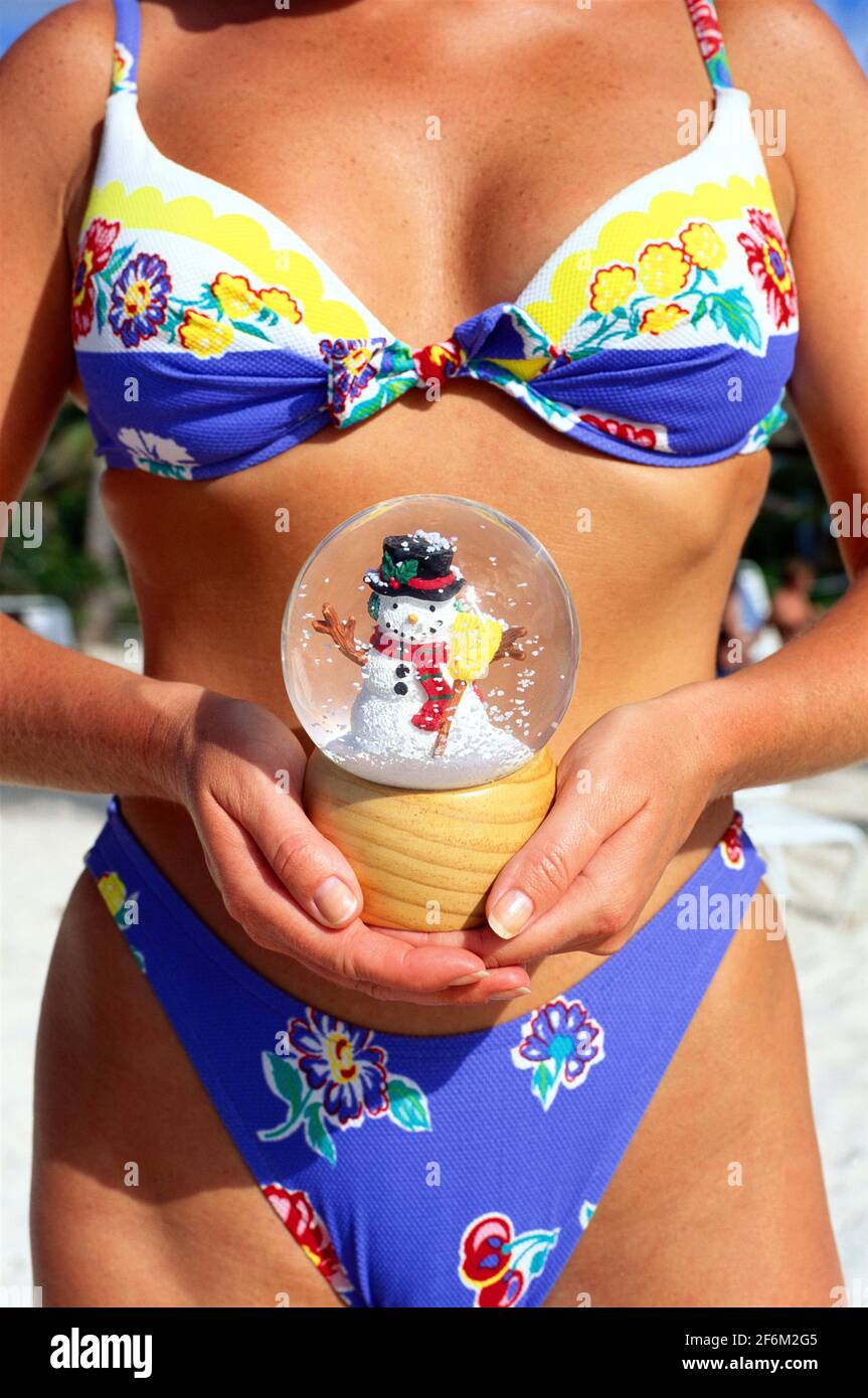Antigua, giovane donna in costume da bagno bikini che tiene un globo di  neve, immagine concettuale della vacanza invernale Foto stock - Alamy