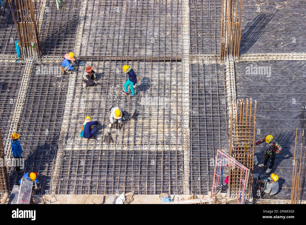 Operai edili che fabbricano grandi barre di rinforzo della barra di acciaio nel cantiere dell'area di costruzione. Foto Stock