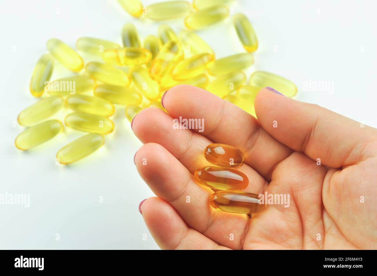 Vitamine. Primo piano di ragazza che tiene la pillola con olio di pesce Omega-3. Nutrizione. Supplementi nutrizionali sani. Sport, concetto di dieta. Foto Stock