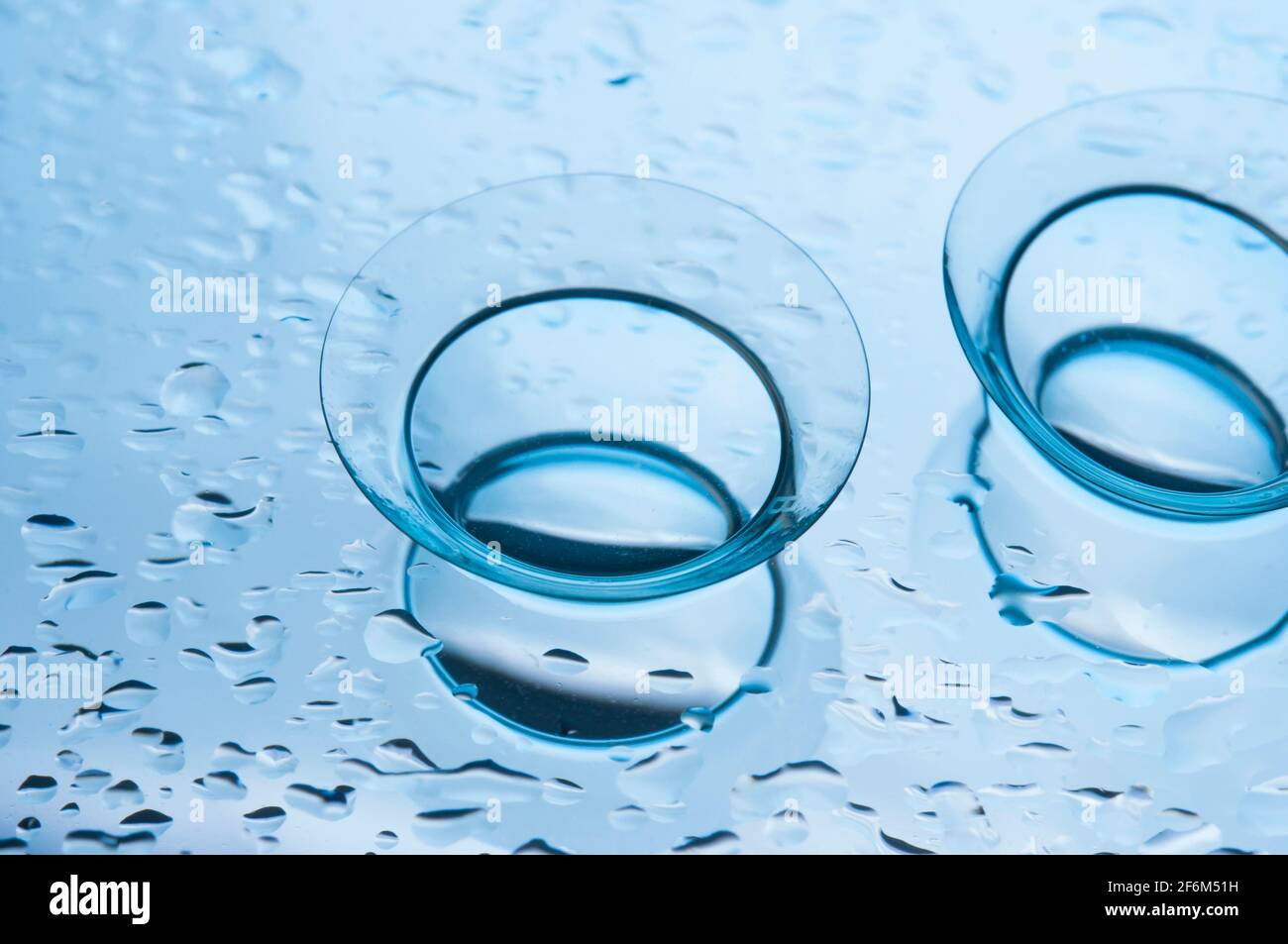 Lenti a contatto con gocce, su sfondo blu. Foto Stock