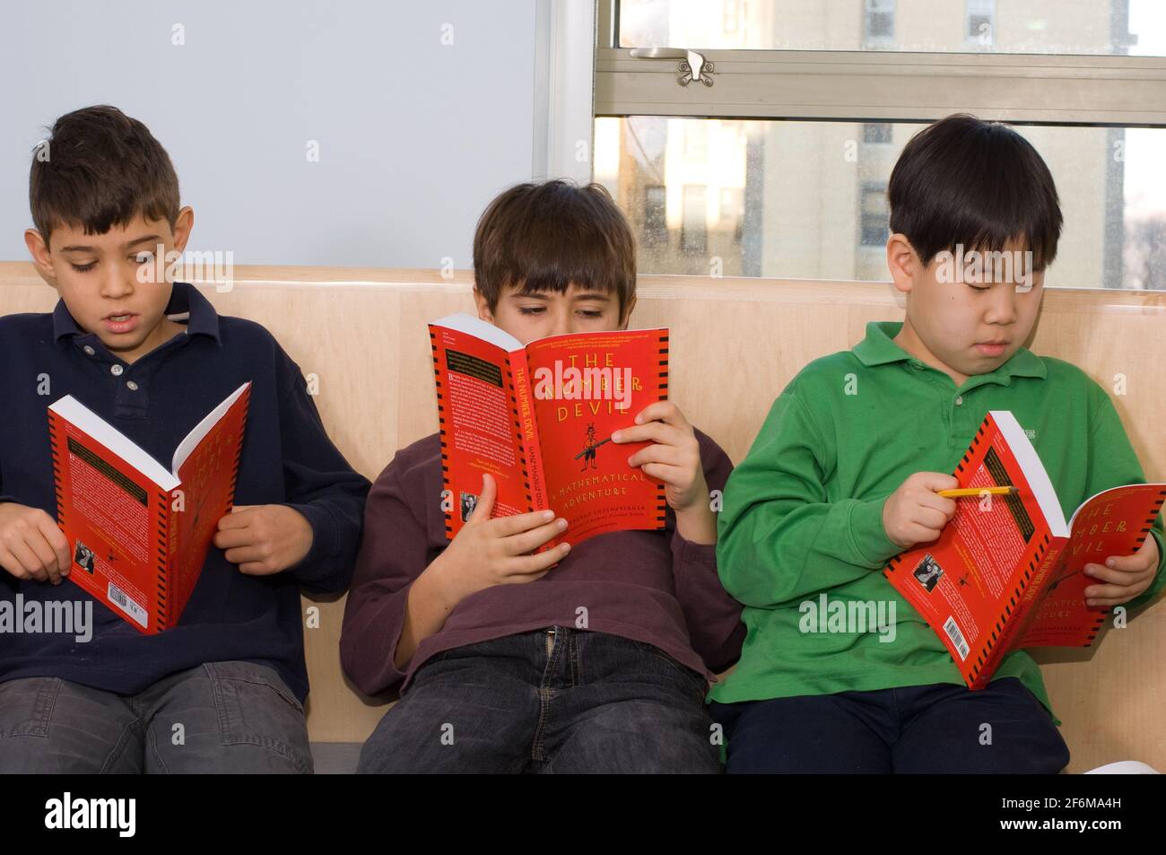 New york City scuola elementare indipendente grado 4 età 9-10 Gruppo matematico di ragazzi che leggono il Diavolo numero Foto Stock
