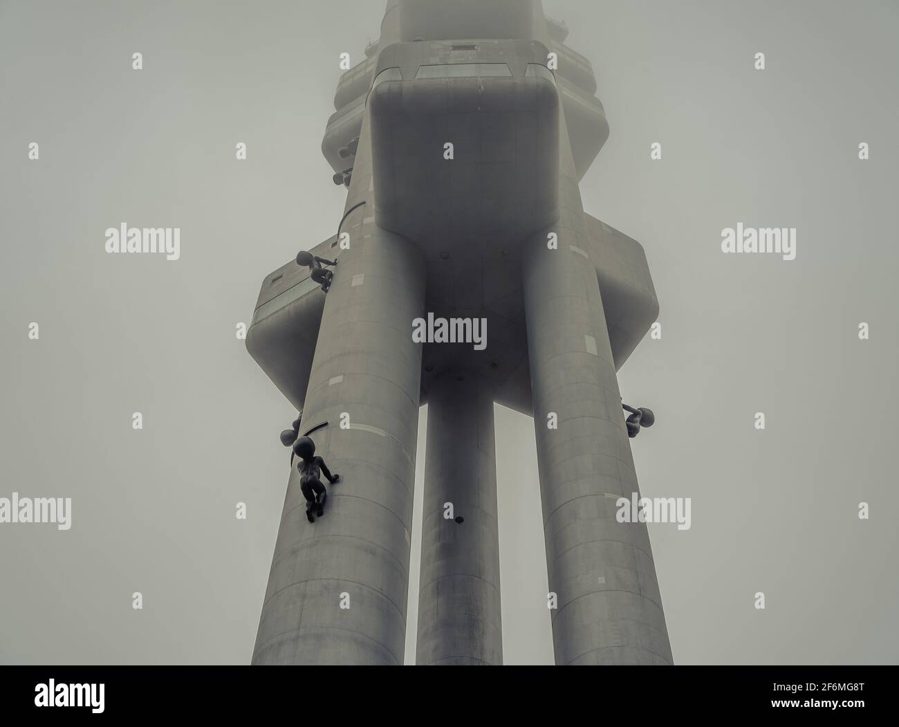 Torre della televisione di Zizkov - Žižkovská věž - con sculture di 'Babies' (Miminka) di David Cerny in un giorno misteriosa; Torre della TV di Žižkov a Mahlerovy Sady, Praga Foto Stock