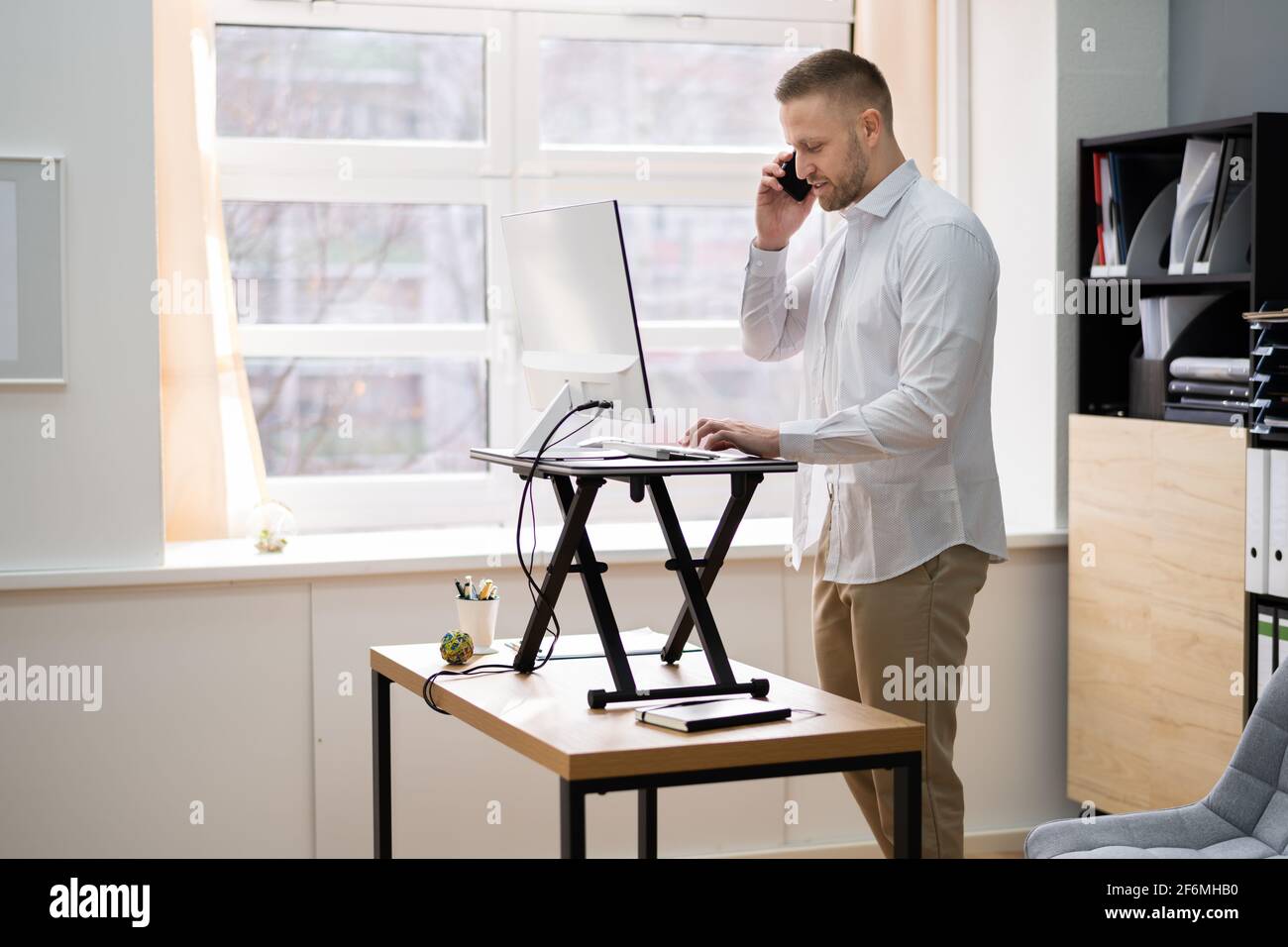 Supporto da scrivania ad altezza regolabile per computer da ufficio Foto Stock