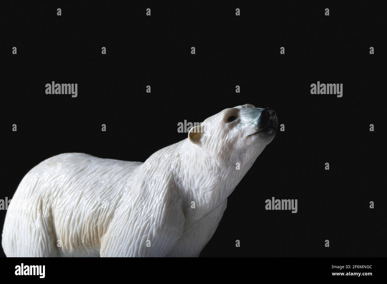 Animale giocattolo in plastica con orso polare su sfondo nero Foto Stock