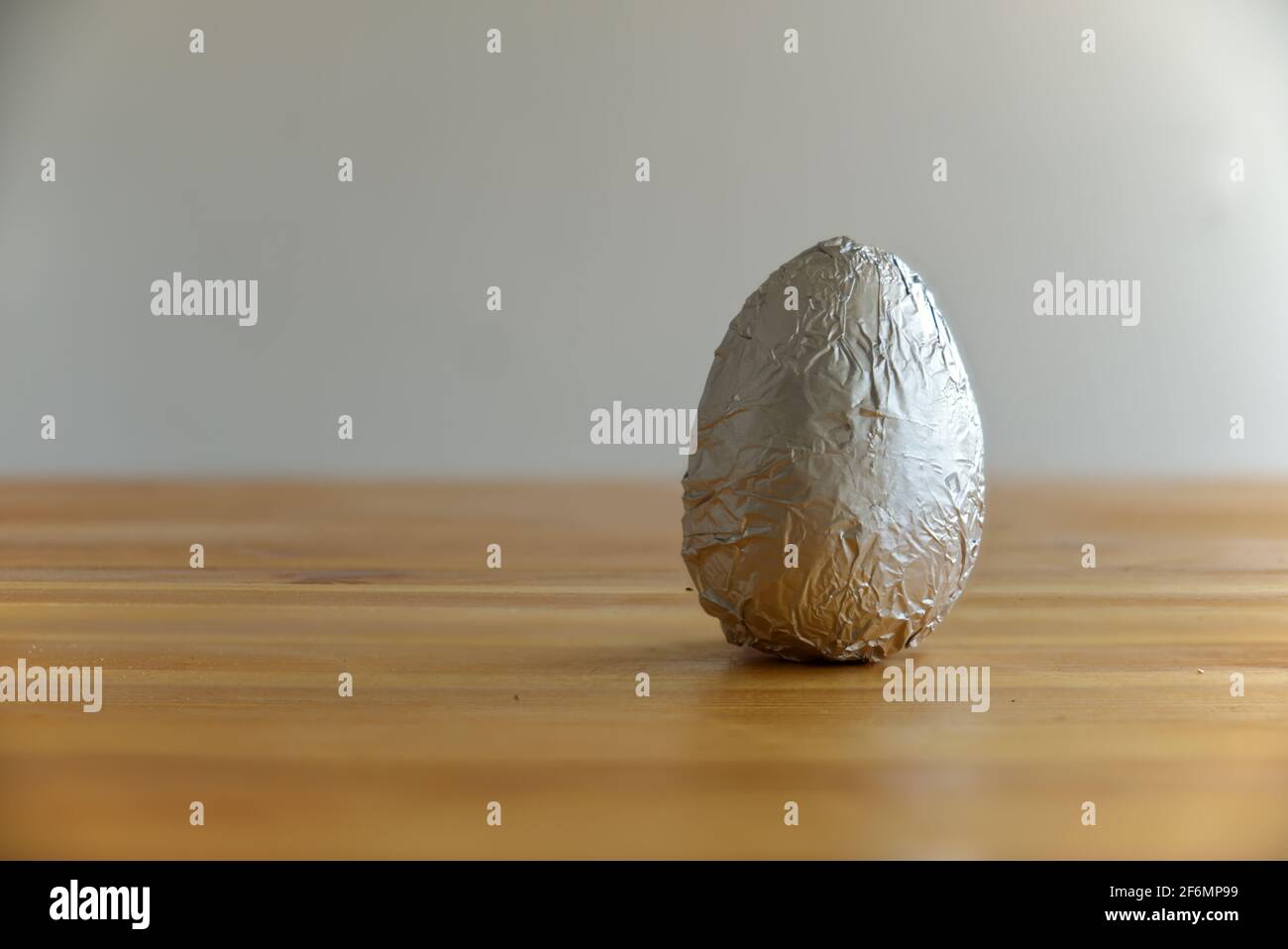 un classico uovo di cioccolato poggiato sul tavolo Foto Stock