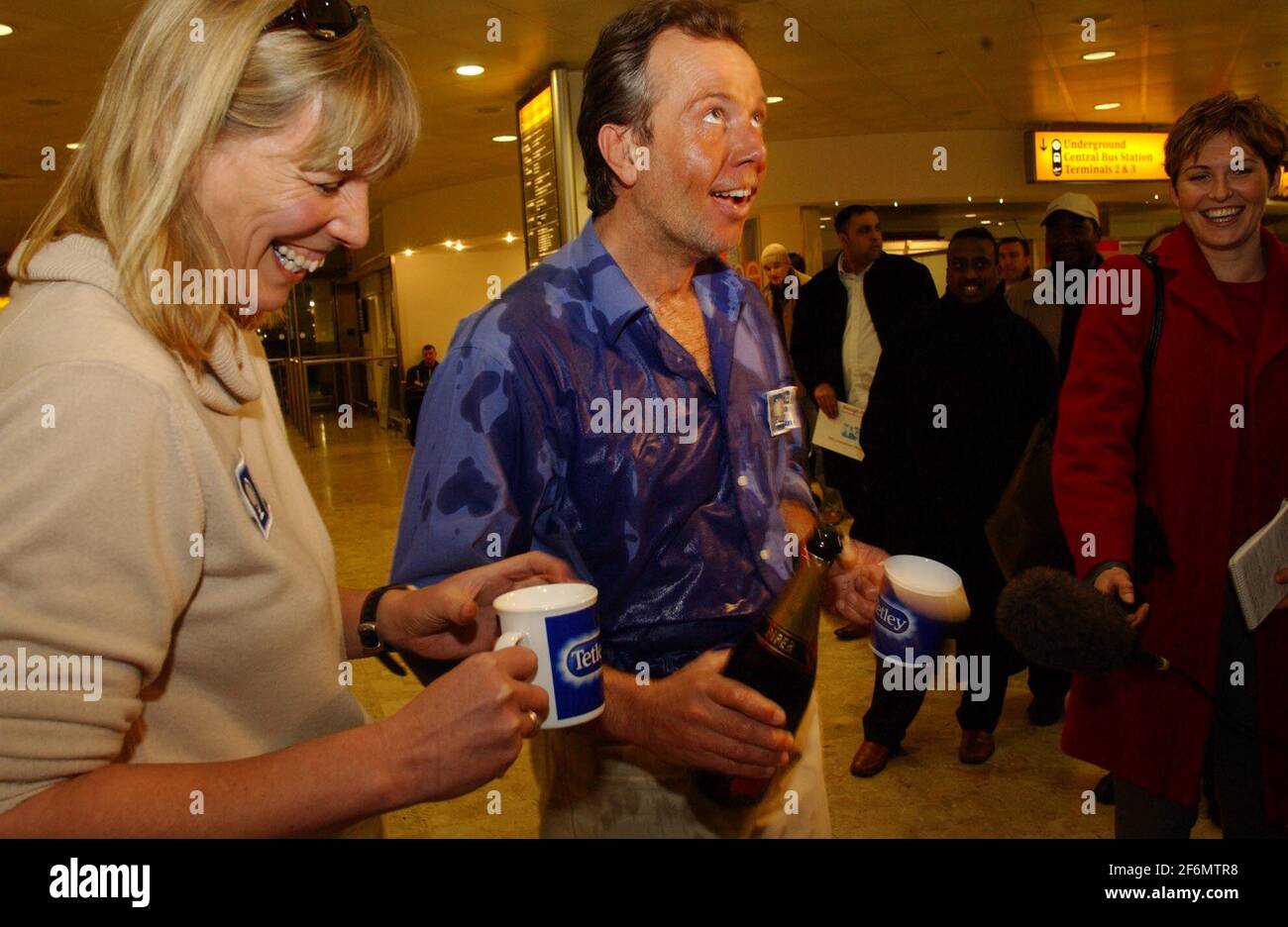 PEN HADOW CON SUA MOGLIE AL SUO ARRIVO A HEATHROW DOPO IL SUO TREKKING AL POLO SUD.[LO CHAMPAGNE È ANDATO VIA NELLE SUE MANI]. 2/2/04 PILSTON Foto Stock