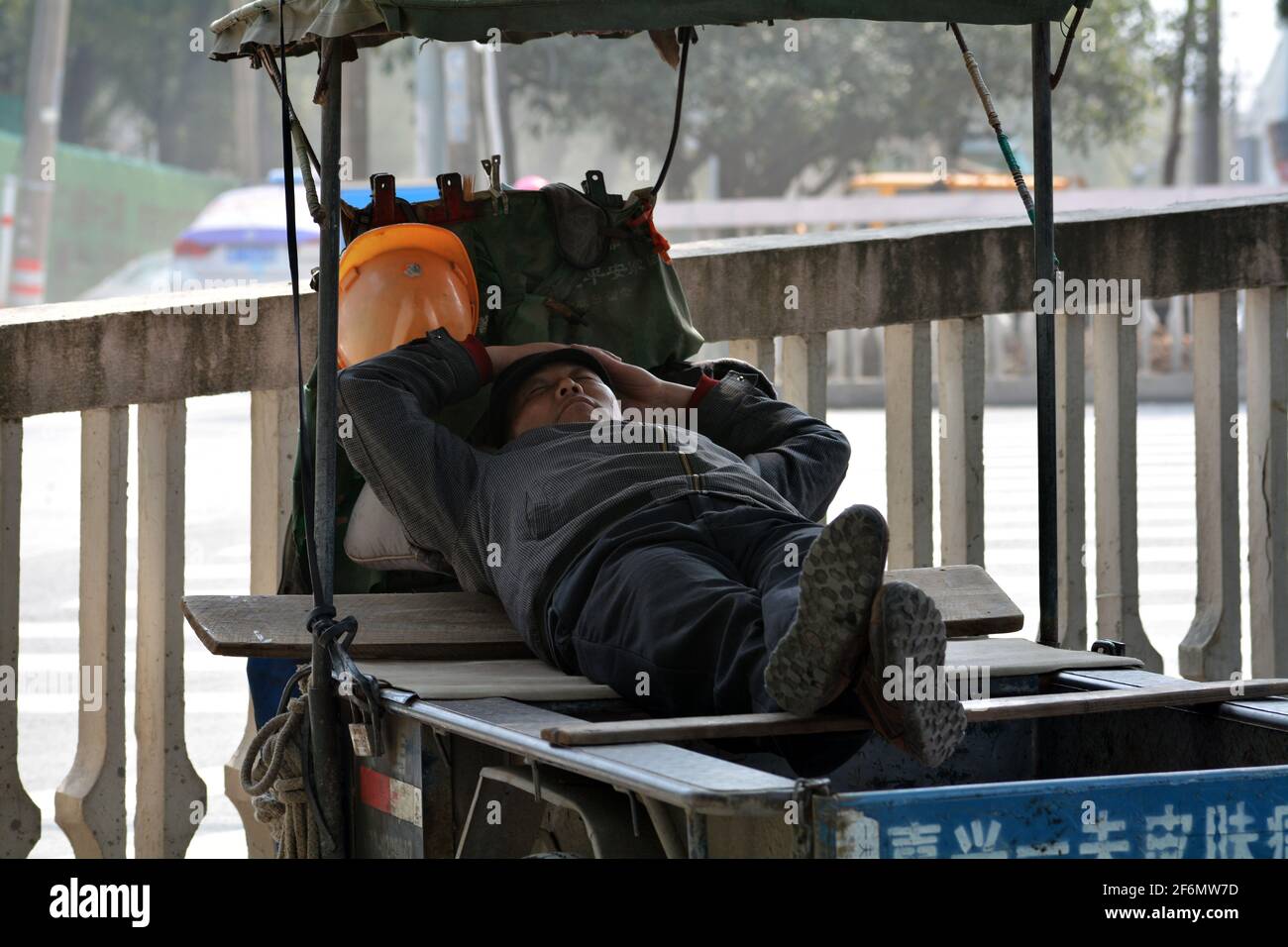 Scena cinese comune durante la metà della giornata, la gente prende appena un pisolino dovunque si trovano. Foto Stock